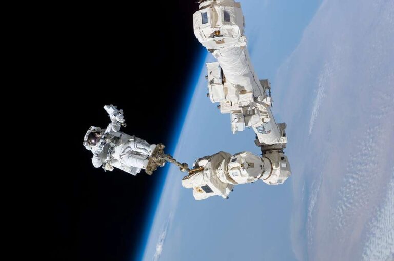 STS-114 mission specialist Astronaut Stephen K. Robinson anchored to the Canadarm2 in the International Space Station.
